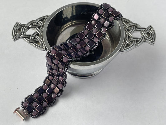 Close up image of bracelet draped over a Scottish quaiche