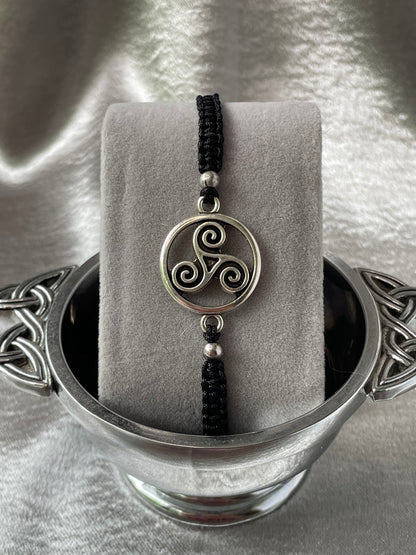 Celtic try charm on macrame bracelet band with bead stoppers close up placed on bracelet stand in silver quaiche