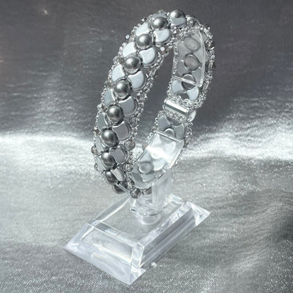 Silver Czech glass and crystal bead bracelet on a clear plastic stand with silver satin background